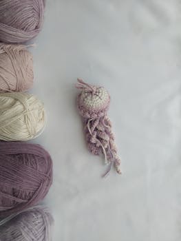 Colorful crochet jellyfish surrounded by skeins of yarn on a flatlay.