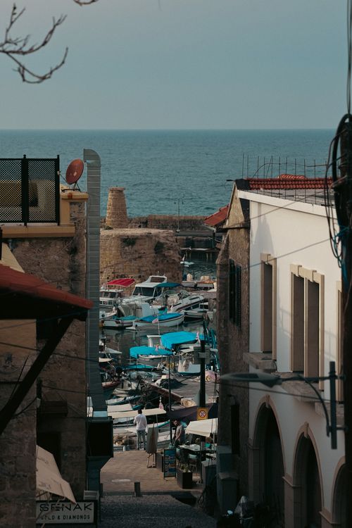 Free A captivating view of boats in Gazimağusa harbor, framed by historic architecture and the sea beyond. Stock Photo
