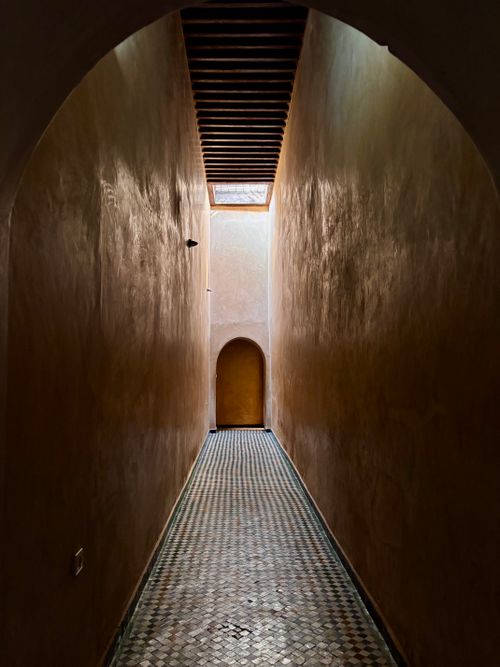 Free A beautifully lit narrow corridor with a patterned mosaic floor in a classic architectural style. Stock Photo