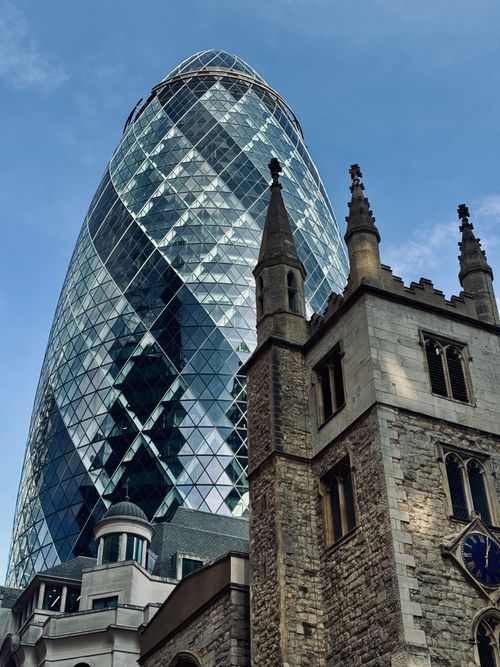 Free Stunning juxtaposition of modern Gherkin and historic St Helen's Church in London cityscape. Stock Photo