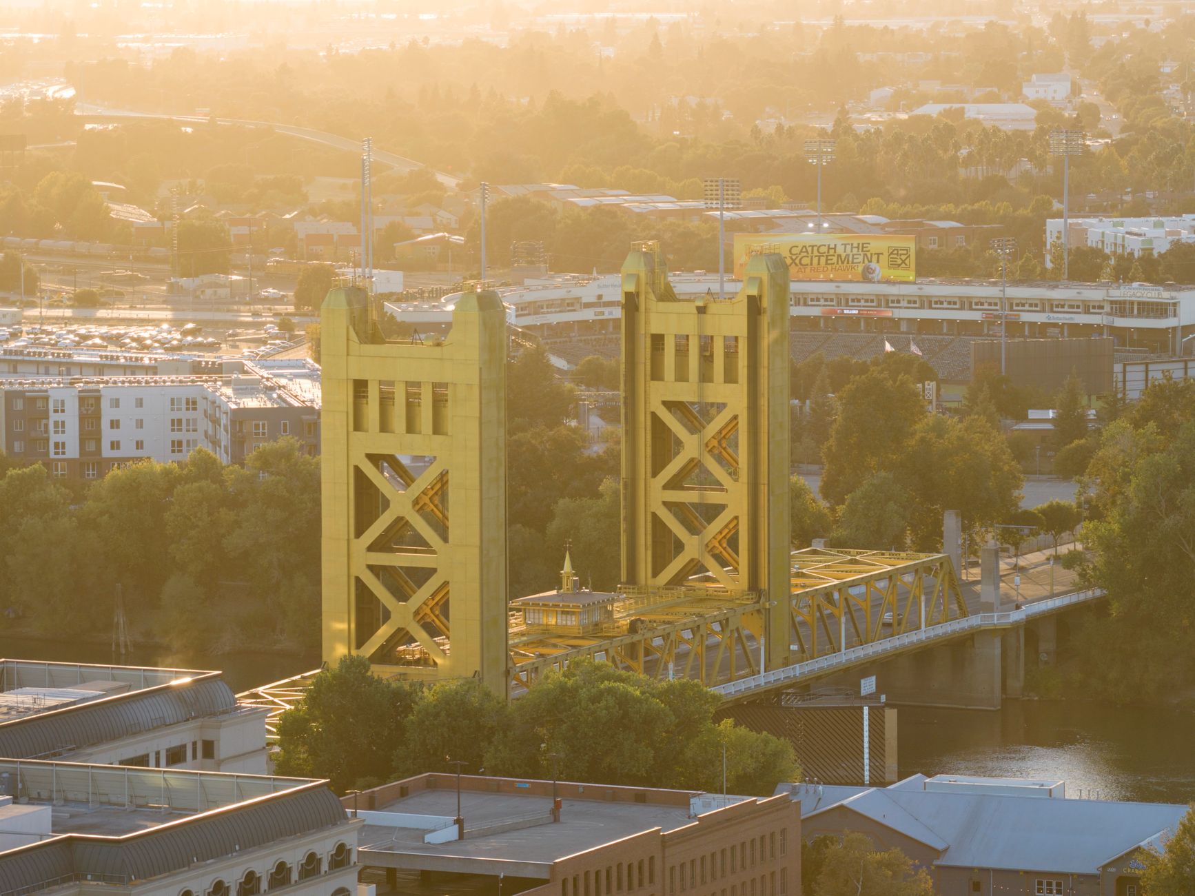 Aerial view of Sacramento's iconic Tower Bridge at sunset, showcasing its golden architecture and scenic surroundings.