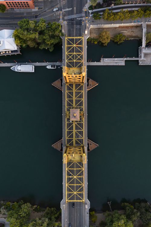 Free Drone perspective of Sacramento's iconic Tower Bridge spanning the river with minimal traffic. Stock Photo