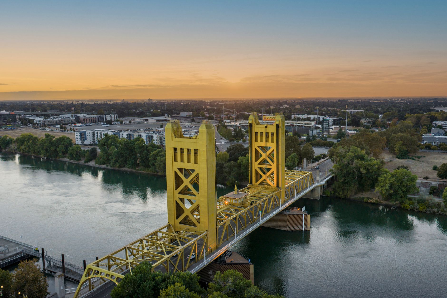 Aerial view of the iconic Tower Bridge in Sacramento, California at sunset, showcasing vibrant cityscape and the Sacramento River.