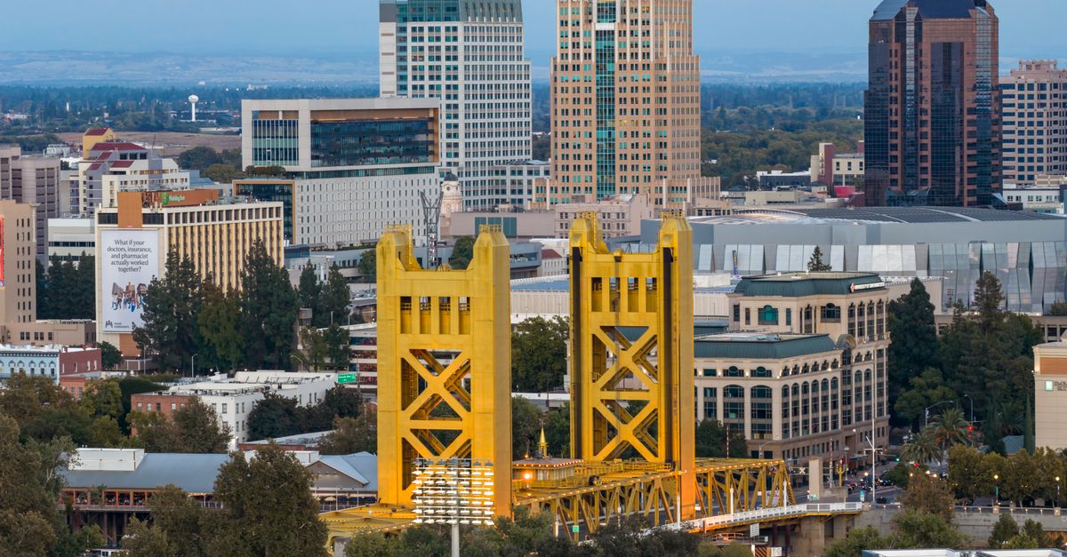 Dramatic aerial view capturing the iconic Tower Bridge and the striking skyline of Sacramento, California at day.