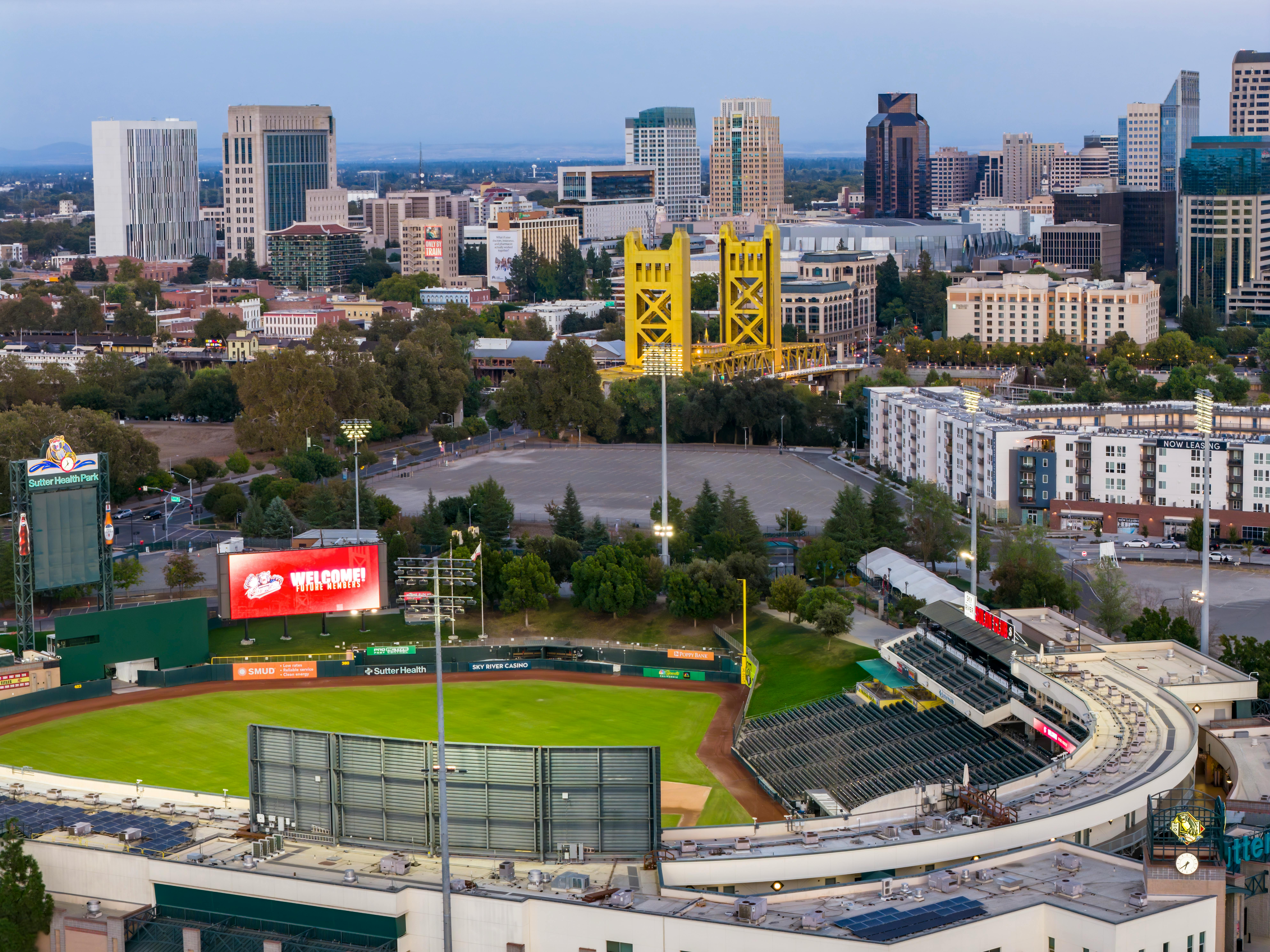 Aerial view of Sacramento featuring the iconic Tower Bridge and Sutter Health Park during the day.