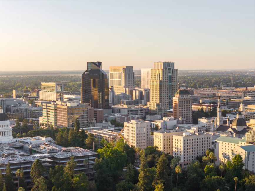 Aerial view of Sacramento skyline with the California State Capitol at sunset, highlighting urban development.