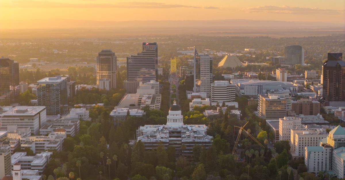 Aerial view of Sacramento cityscape with State Capitol and Tower Bridge at sunset.