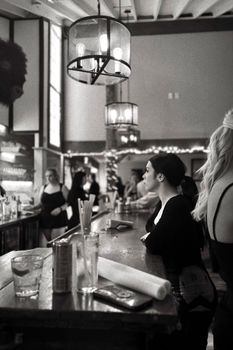 A bustling bar with people engaged in lively conversations and bright decor.