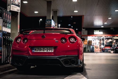 Free Red Nissan GT-R parked at a Sarajevo gas station at night, capturing urban automotive elegance. Stock Photo