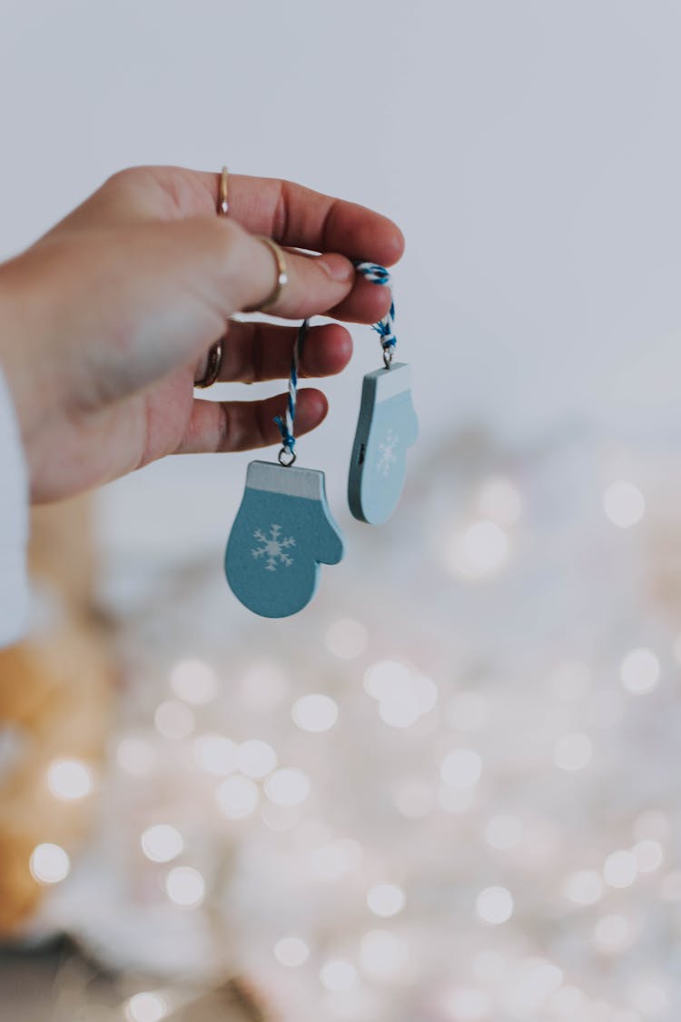 Shallow Focus Photo Of Person's Hand Holding Christmas Ornament Mittens