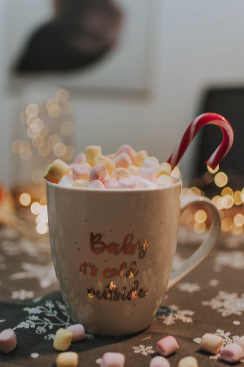 Mug of hot Christmas drink with marshmallows and candy