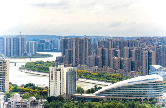Aerial view of a modern cityscape with tall buildings and a winding river.