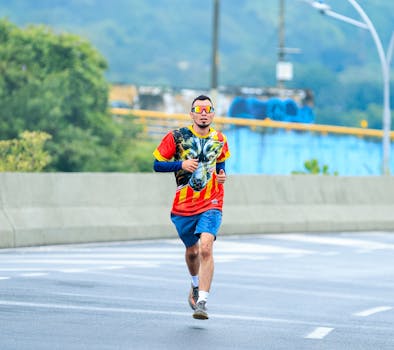 A man in vibrant clothing jogging on a wet city road, displaying urban fitness lifestyle.