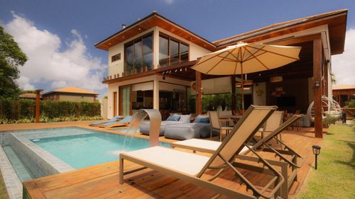 Free Elegant villa featuring a private pool and sun loungers for ultimate relaxation. Stock Photo