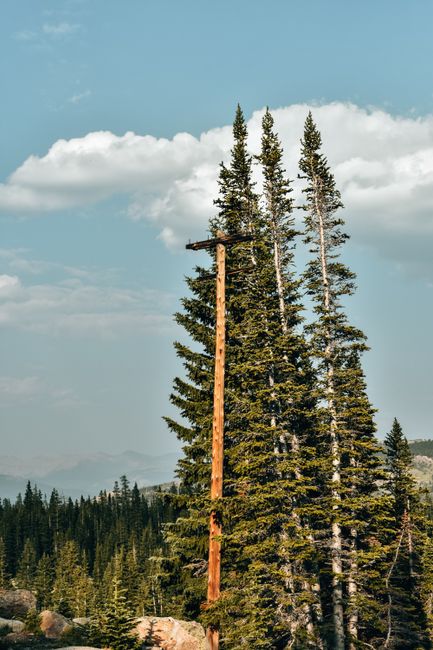 Sunrise over a Colorado mountain lake with a tent and pine trees