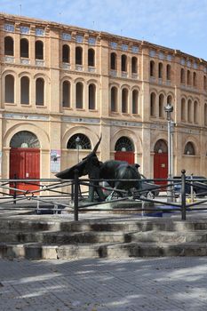 Capture of El Puerto de Santa María's bullring and a bull sculpture on a sunny day.