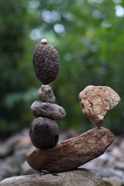 Fotomural Una exhibición creativa de equilibrio con piedras apiladas sobre un fondo natural borroso.