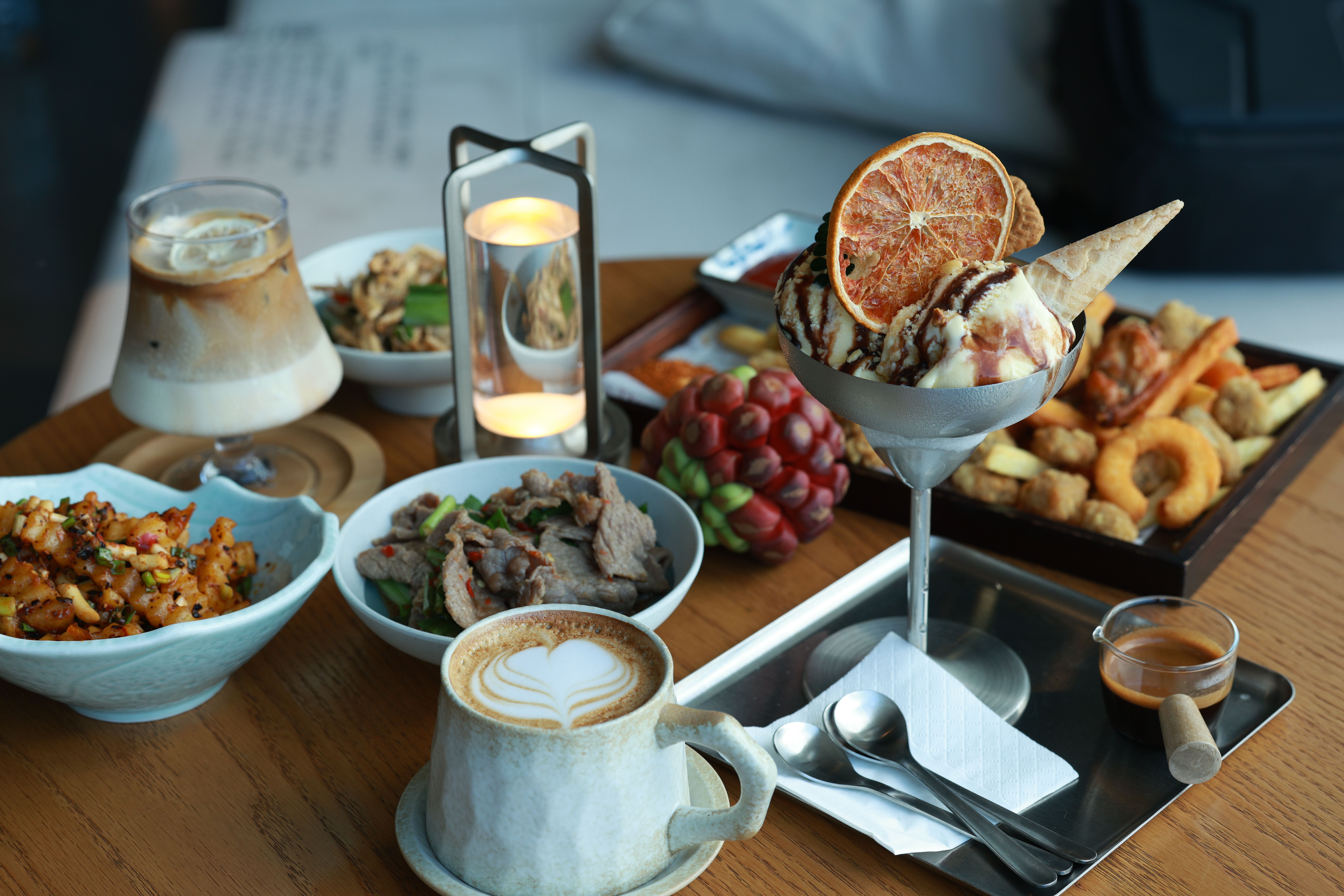 A variety of gourmet dishes and desserts beautifully arranged on a wooden table.