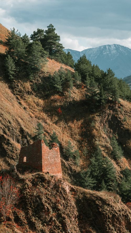 Free Explore an ancient ruin nestled in a mountainous forest landscape, evoking history and adventure. Stock Photo