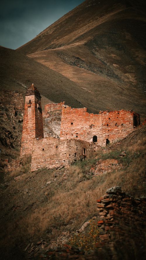 Free Explore ancient ruins set against a stunning mountainous backdrop, showcasing history and nature. Stock Photo