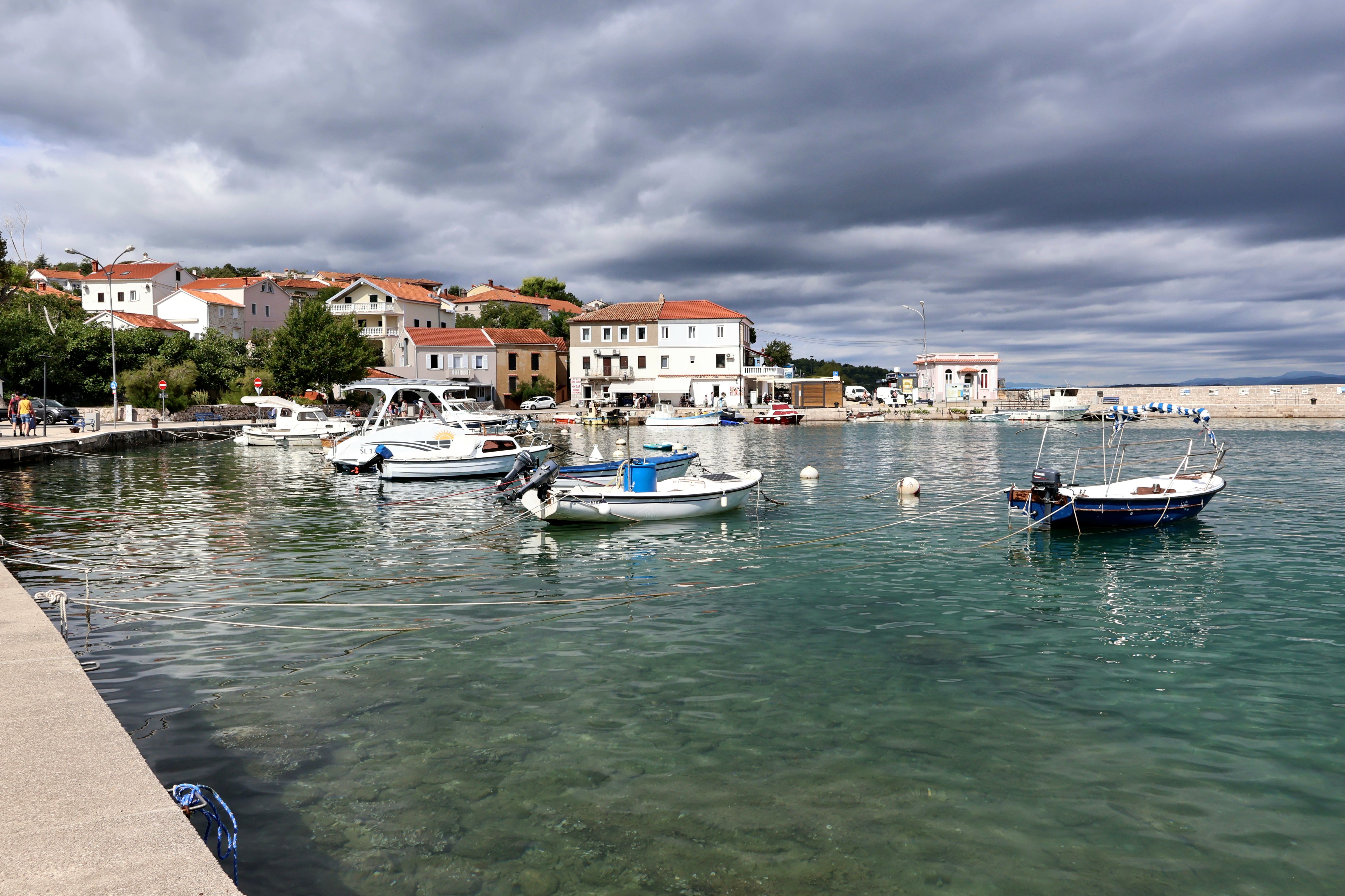 small fishing boats docked at harbor before storm