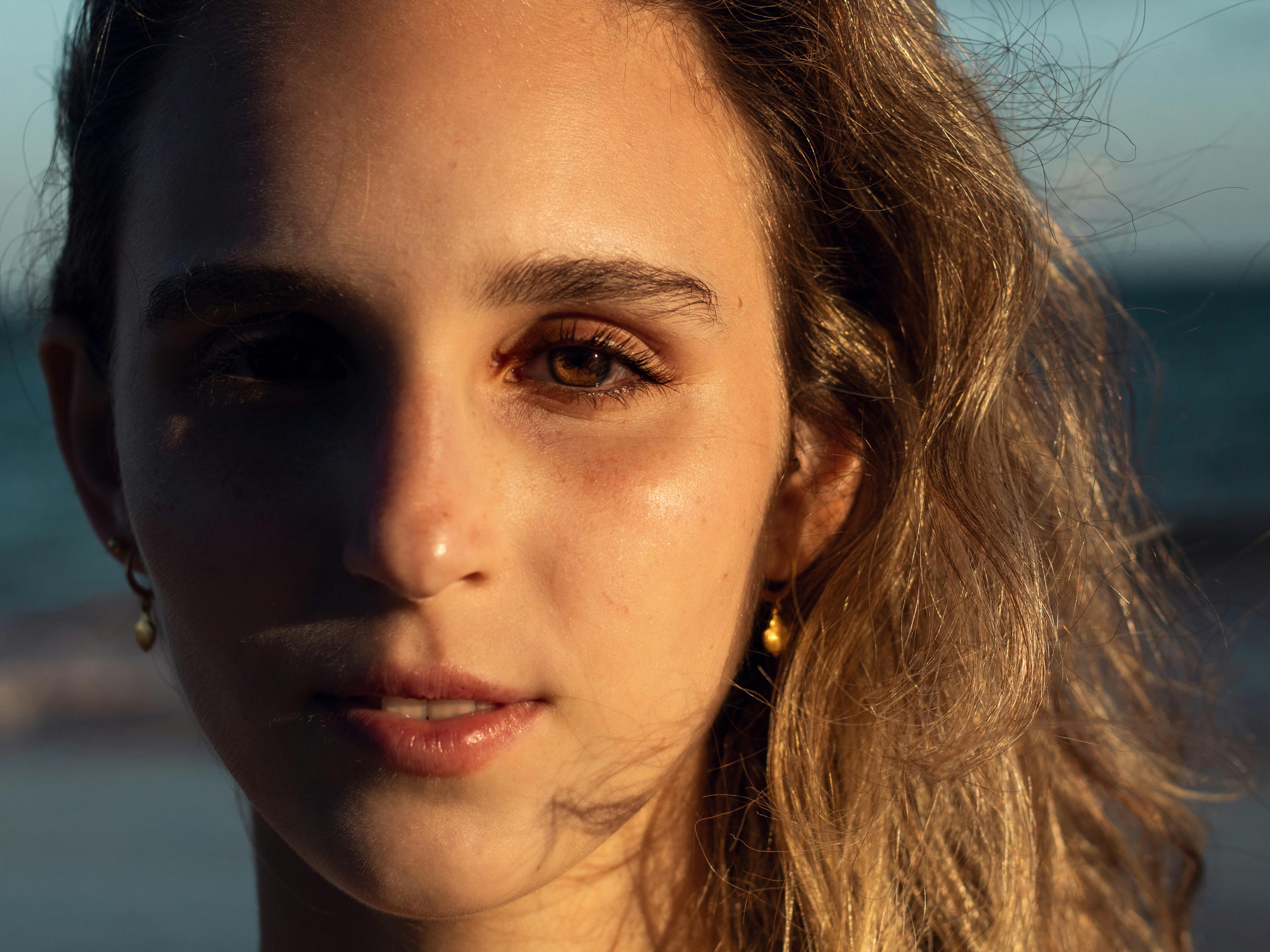 一个女人的特写肖像，她的脸上映着海滩上的阳光