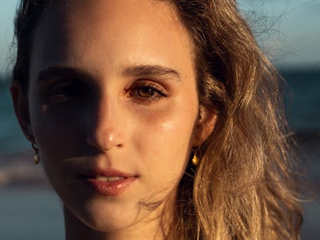 一个女人的特写肖像，她的脸上映着海滩上的阳光