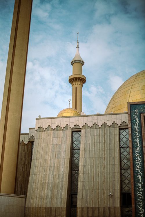 Free Exterior view of a mosque with dome and tall minaret against a blue sky, featuring ornate design. Stock Photo