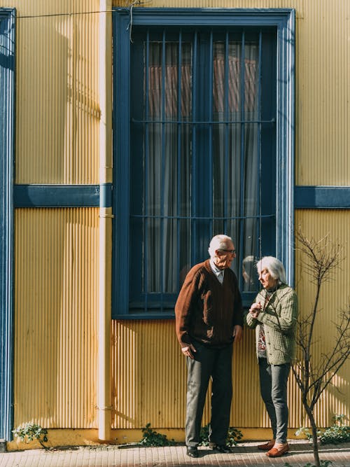 建物の窓の前に立っている男女