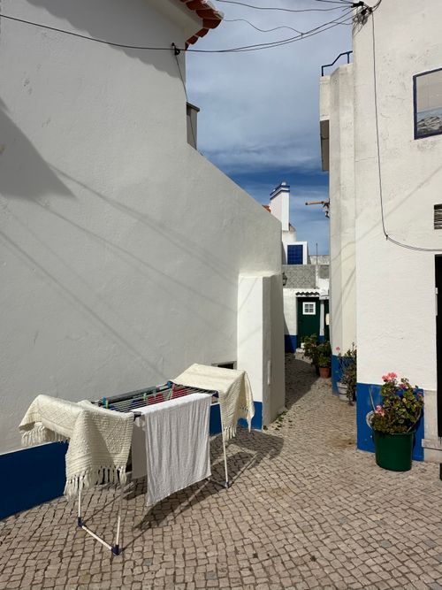 Free Picturesque alley with whitewashed houses and laundry in Ericeira, Portugal. Stock Photo