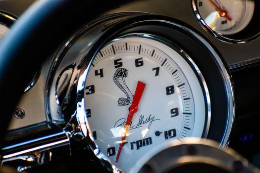 Detailed view of a classic Shelby Mustang speedometer featuring iconic cobra emblem.
