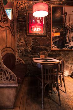 Warm and inviting vintage café interior with stone walls and wooden seating. Perfect leisure spot.