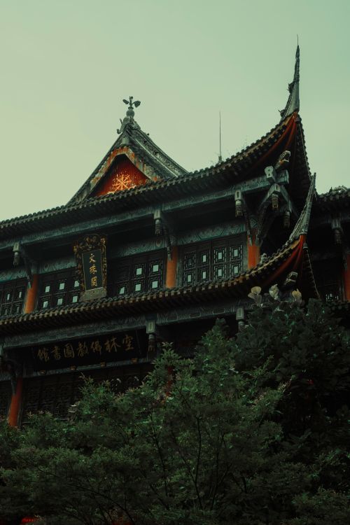 Free A beautifully detailed traditional Asian temple with ornate roof and lush greenery. Stock Photo