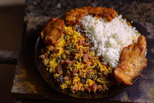 Authentic Brazilian dish with rice, bean mixture, and fried chicken pieces.