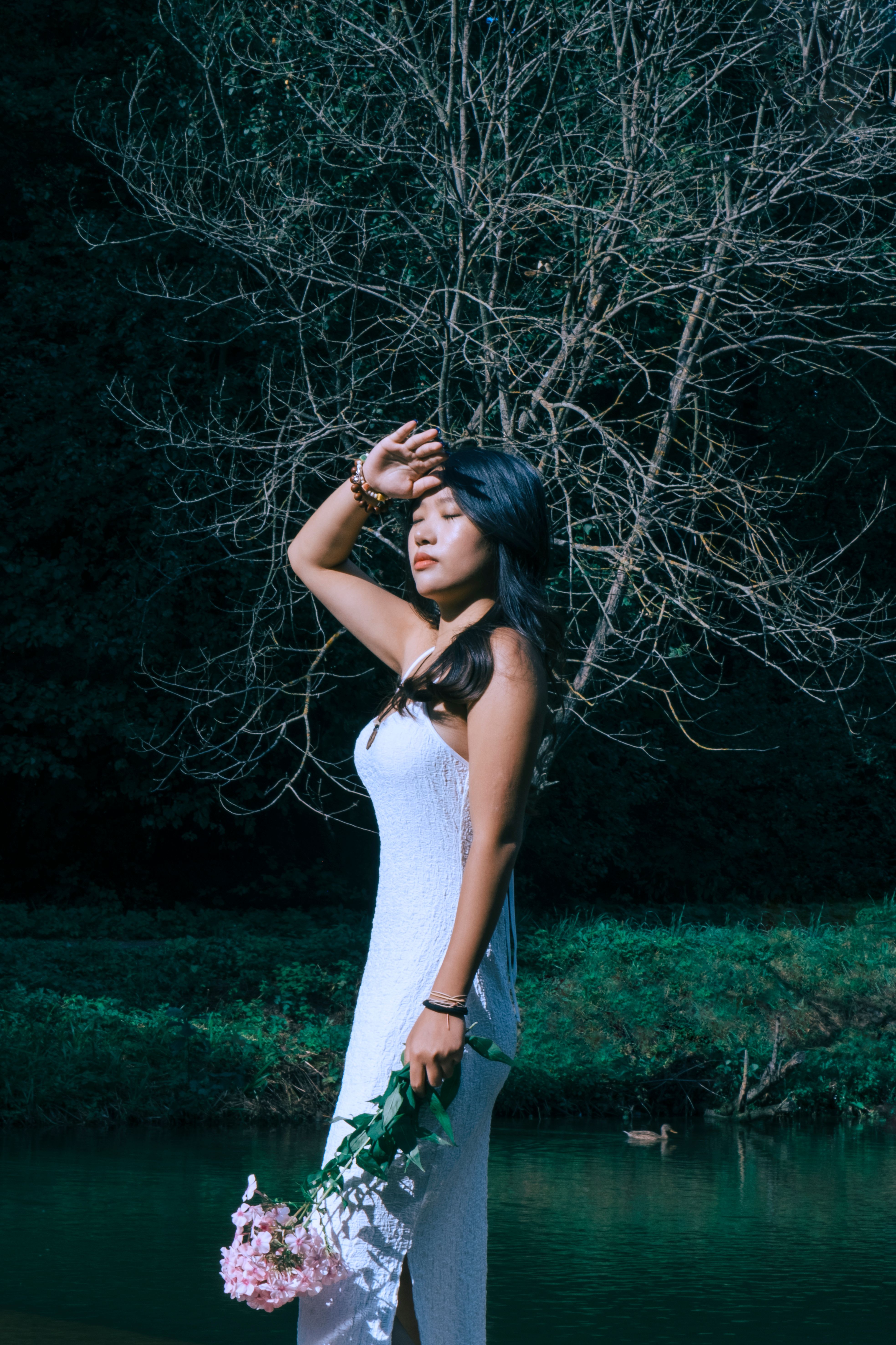 Elegant Woman Posing by a Bare Tree Outdoors · Free Stock Photo
