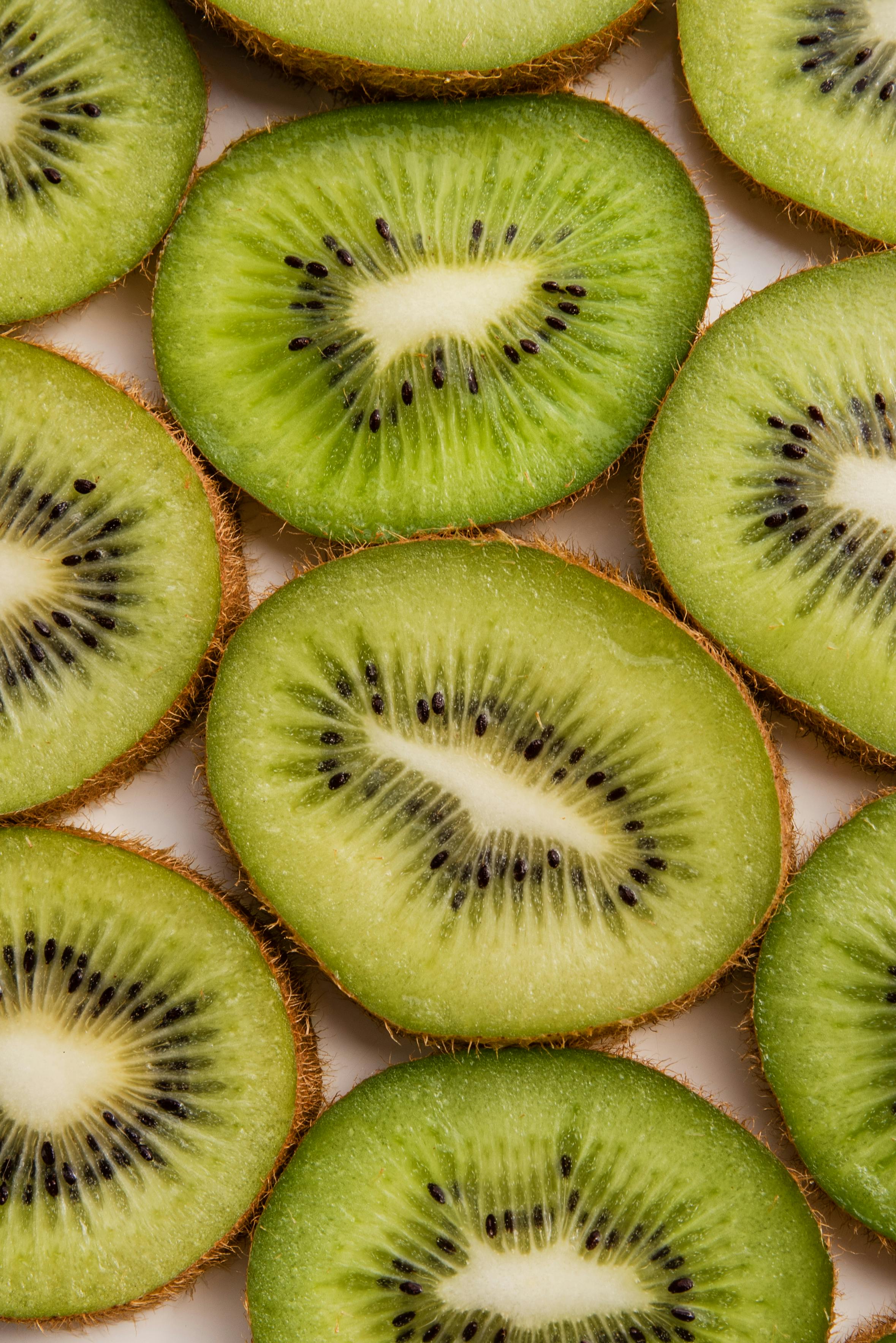 Close-up of fresh sliced kiwi fruits showcasing the vibrant green texture and seeds.