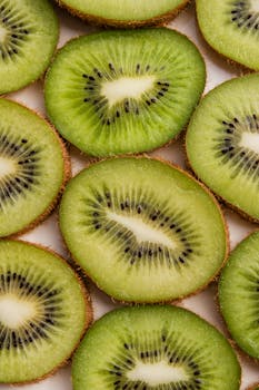 Close-up of fresh sliced kiwi fruits showcasing the vibrant green texture and seeds.