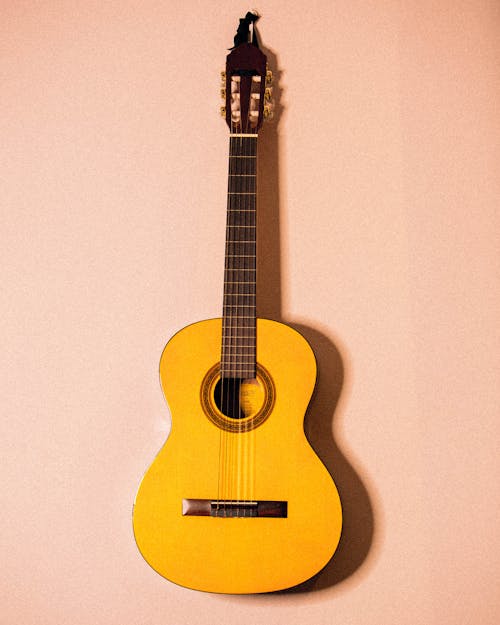 Ücretsiz Pembe Duvara Asılmış Sarı Gitar Fotoğrafı Stok Fotoğraflar