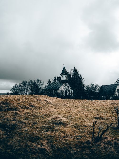 Free A dramatic landscape featuring a historical church amidst cloudy skies in Selfoss, Iceland. Stock Photo