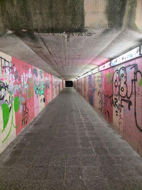 Free A long graffiti-filled tunnel with colorful street art on both walls, creating an urban artistic vibe. Stock Photo