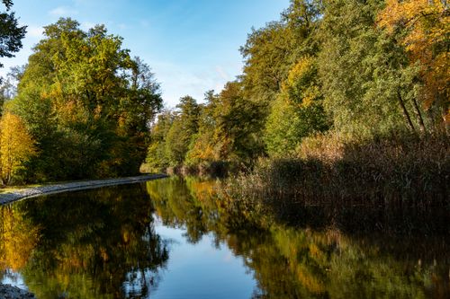 Free Serene autumn river with colorful foliage reflecting in the calm water. Stock Photo