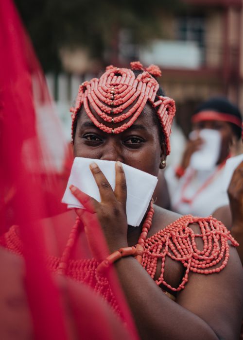 Free African woman wearing traditional coral bead adornments during a cultural ceremony. Stock Photo