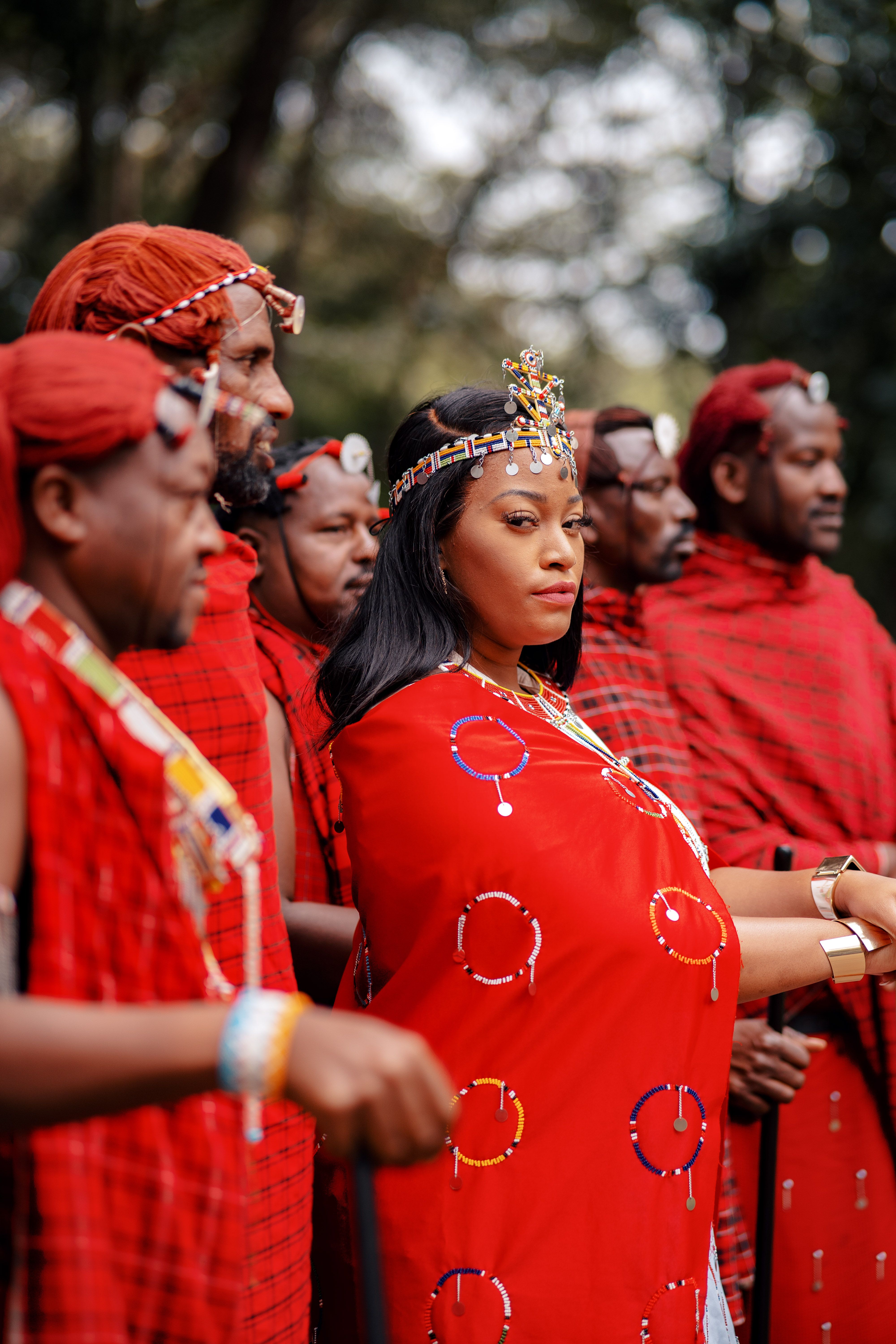 A group of Maasai people in traditional red attire gathered outdoors in Kenya.