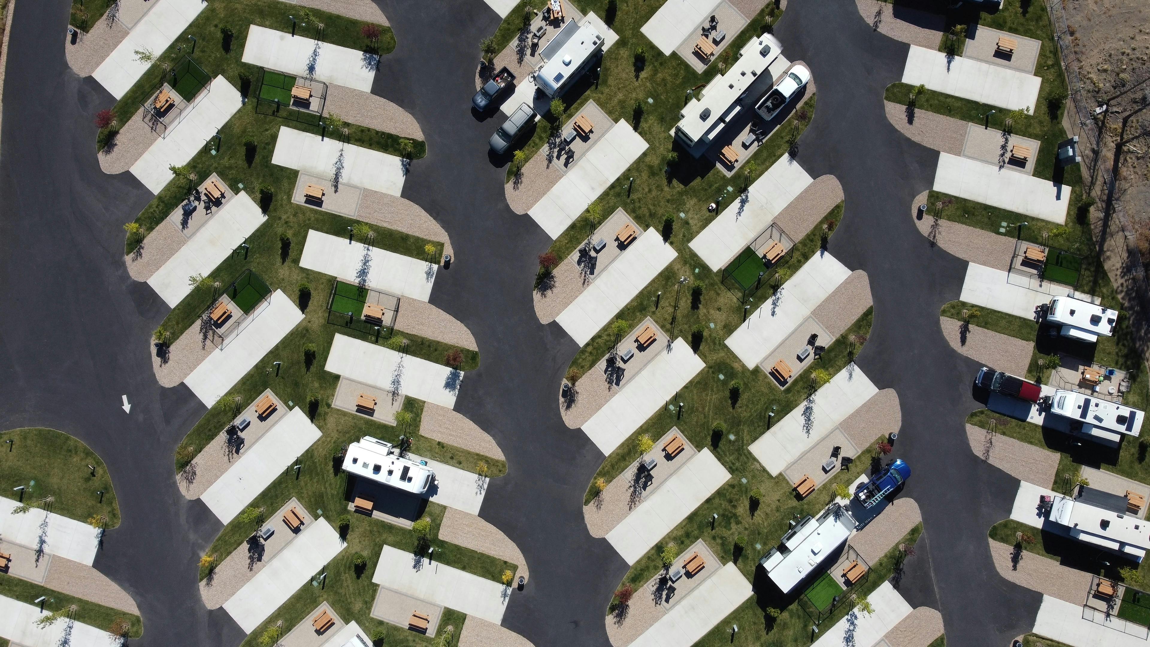 Aerial shot of an organized RV park with trailers and greenery.