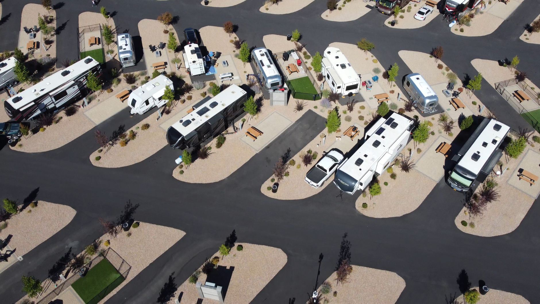Aerial view of parked RVs in a modern campground on a sunny day.