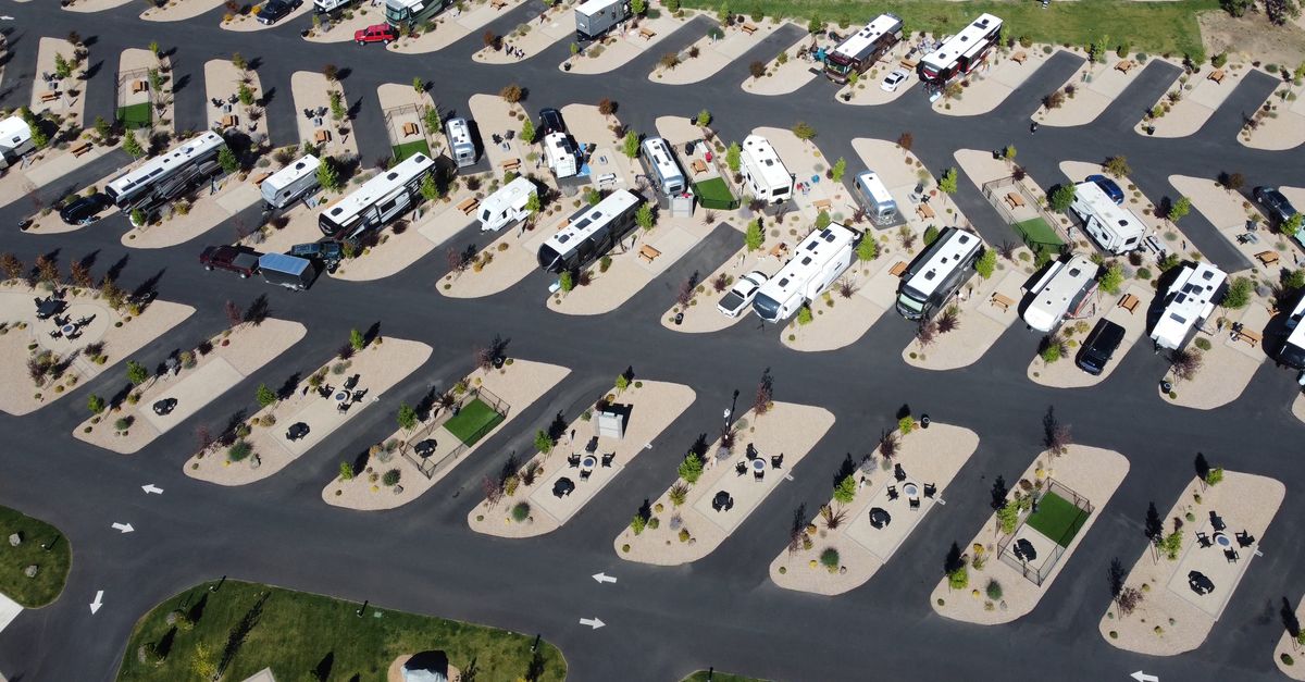 Aerial shot of RV park showcasing organized lots and modern amenities under bright daylight.