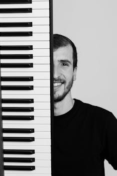 Black and white portrait of a male pianist posing with a keyboard.
