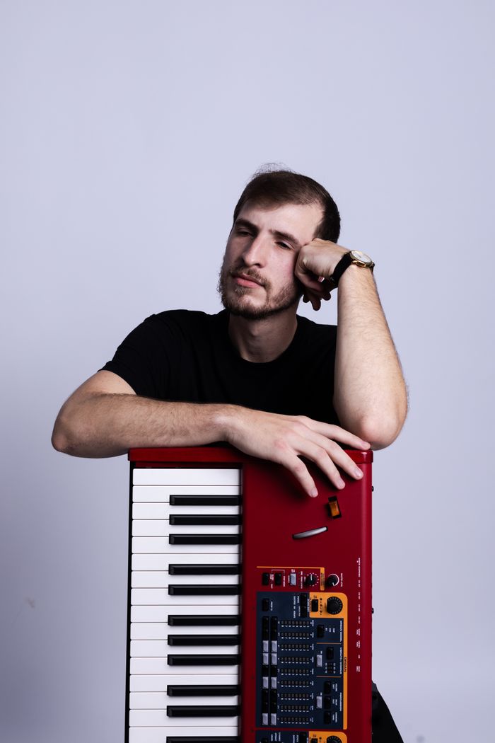 A musician leaning on a red electronic keyboard — photo by Jonathan Goncalves on Pexels