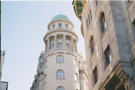 A classic building with a green dome under a clear blue sky, showcasing traditional architectural design.