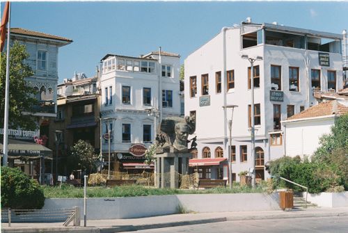 Free A quaint street scene showcasing historic buildings and a notable bust in a vibrant neighborhood. Stock Photo